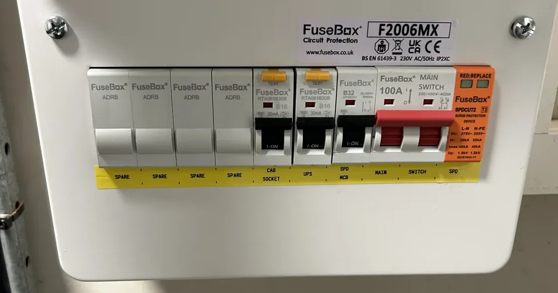 A fuse board (consumer unit) with the cover closed and four spare ways labelled SPARE