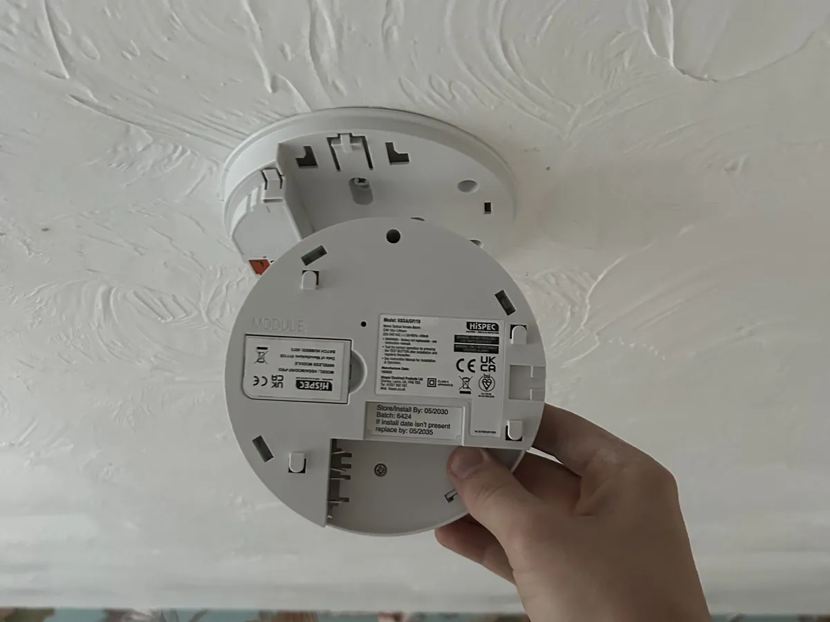 Replacing an optical smoke alarm on its ceiling base