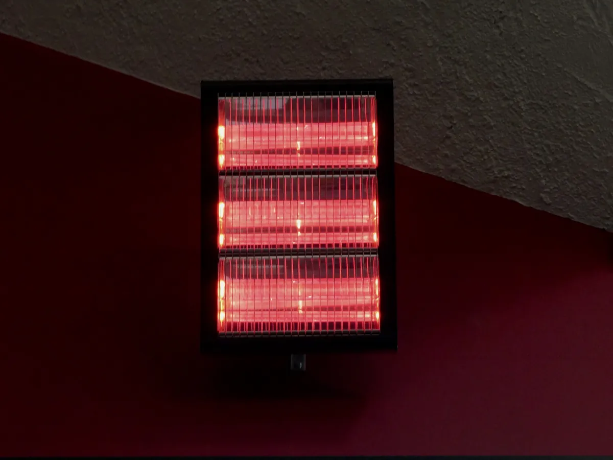 Infrared heater glowing on a red wall