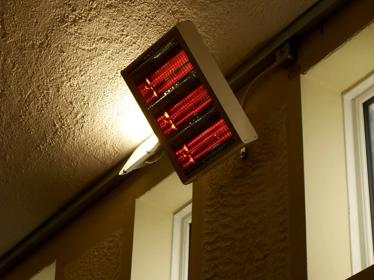 Infrared heater on a bracket beside high windows
