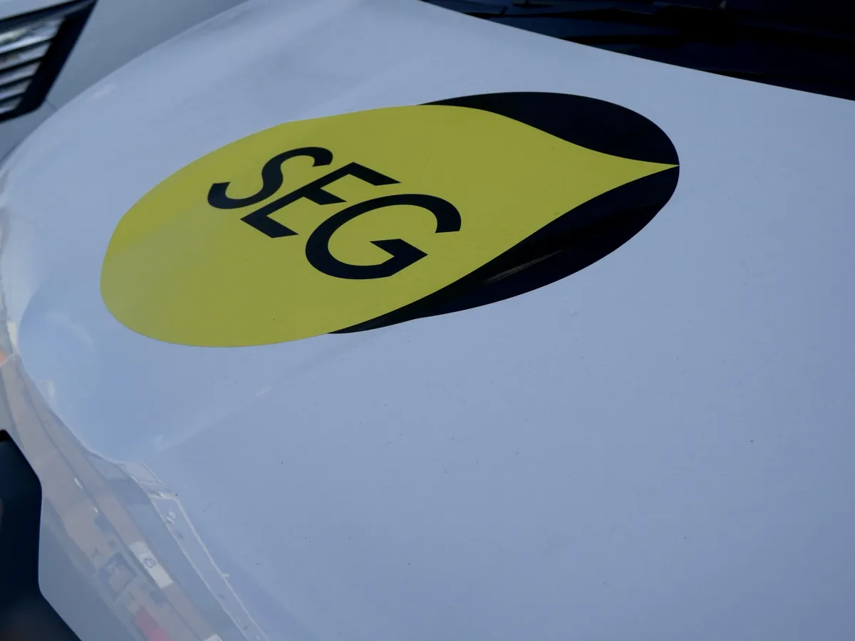Yellow and black SEG roundel on a white van bonnet