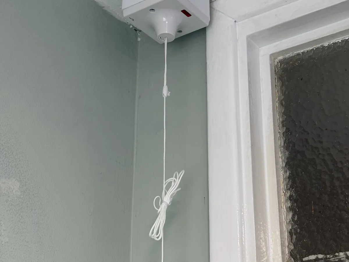 Warden call pull-cord switch on a ceiling