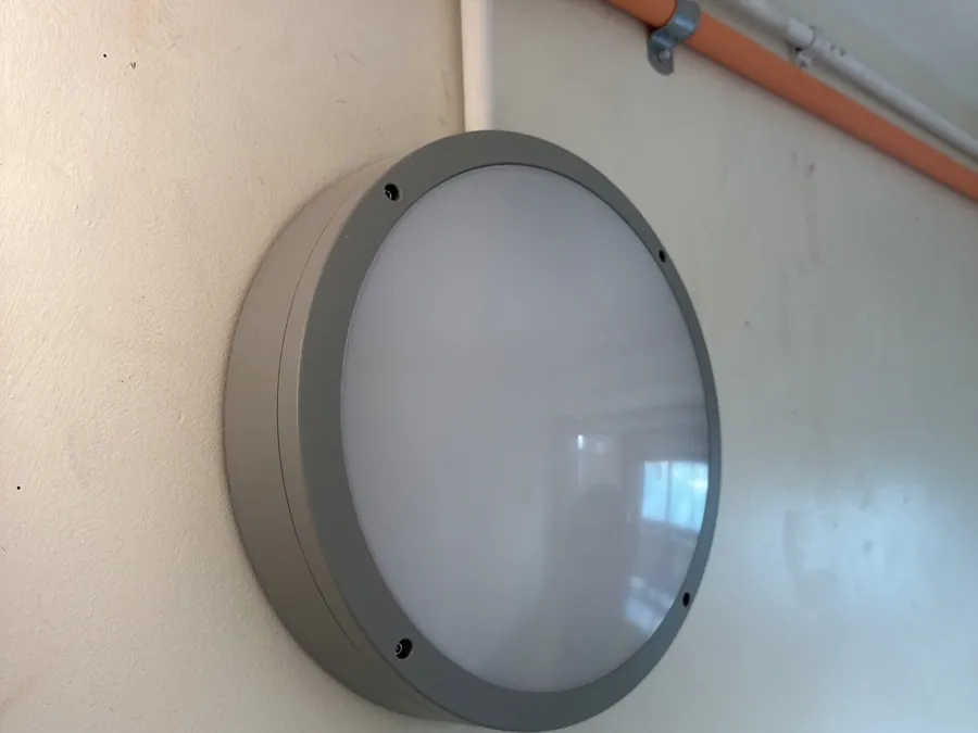 Round LED bulkhead luminaire fixed to a wall