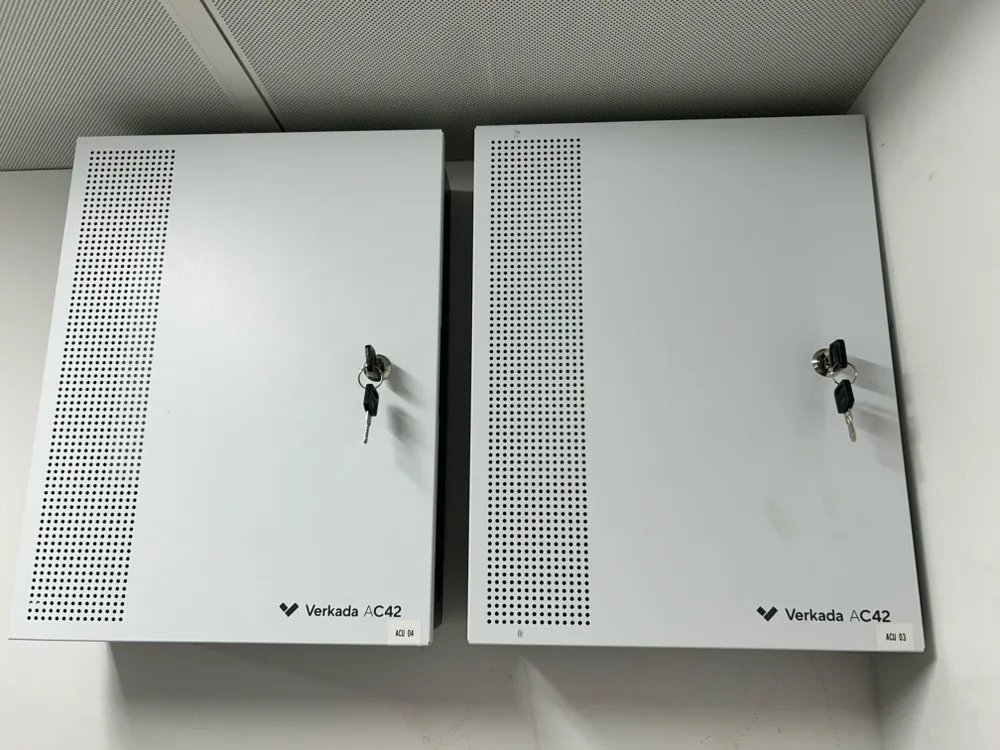 Two door controllers mounted side by side in an office comms room