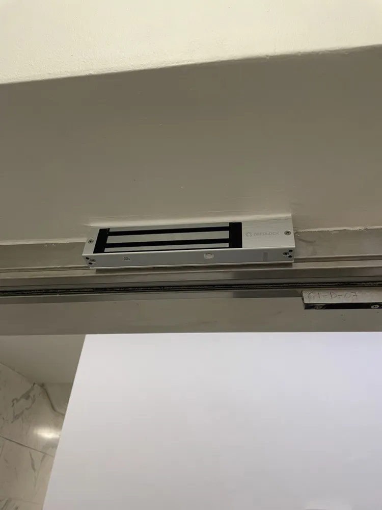 Compact maglock fitted to the head of a glass office entrance door