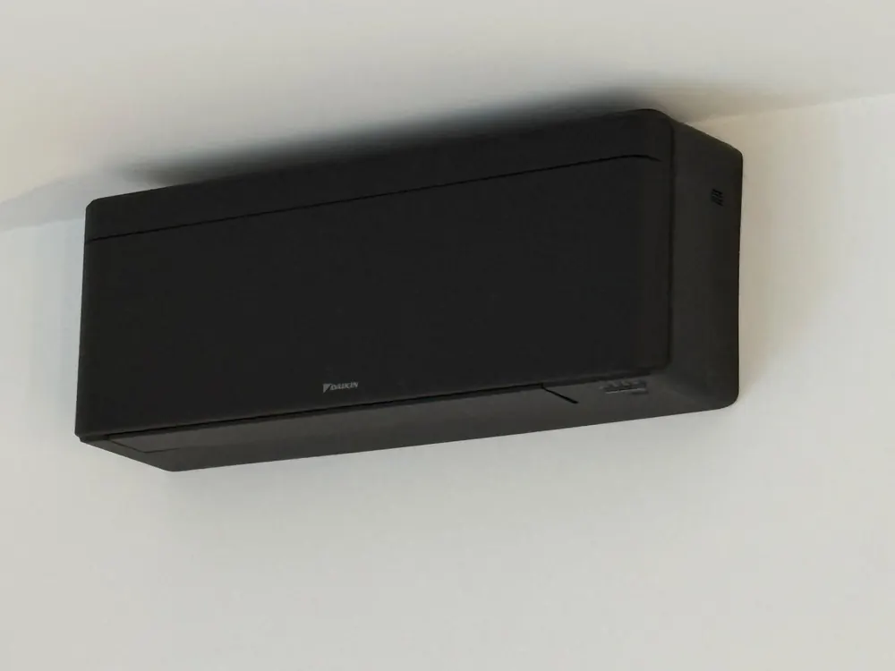 Black Daikin air conditioning unit high on a bedroom wall in Park Street, St Albans
