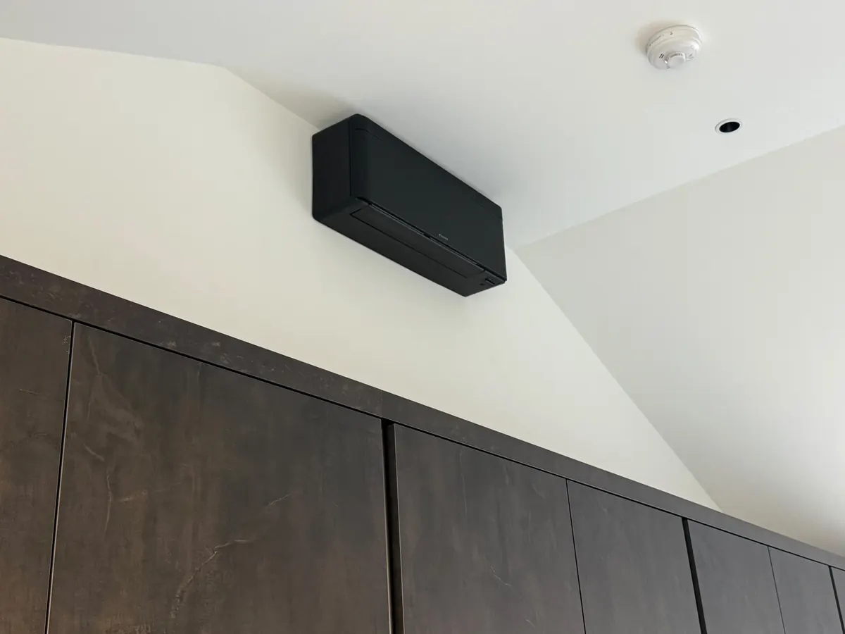 Matt-black Daikin air conditioning unit above kitchen units in a home in Park Street, St Albans