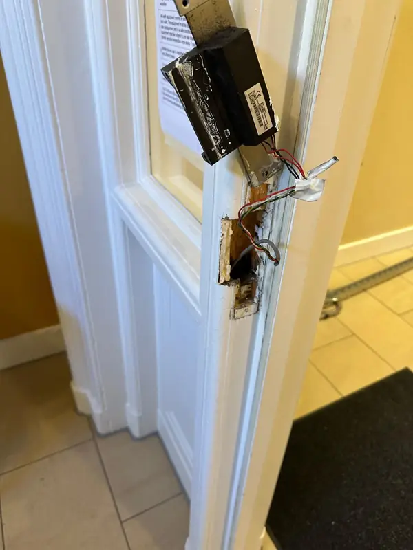 The old door lock hardware coming off the frame