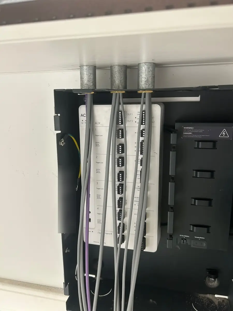 Door cables entering the controller through steel conduit, ready to terminate