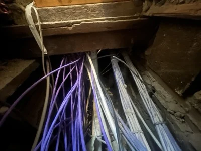 Data cables under the floorboards between rooms