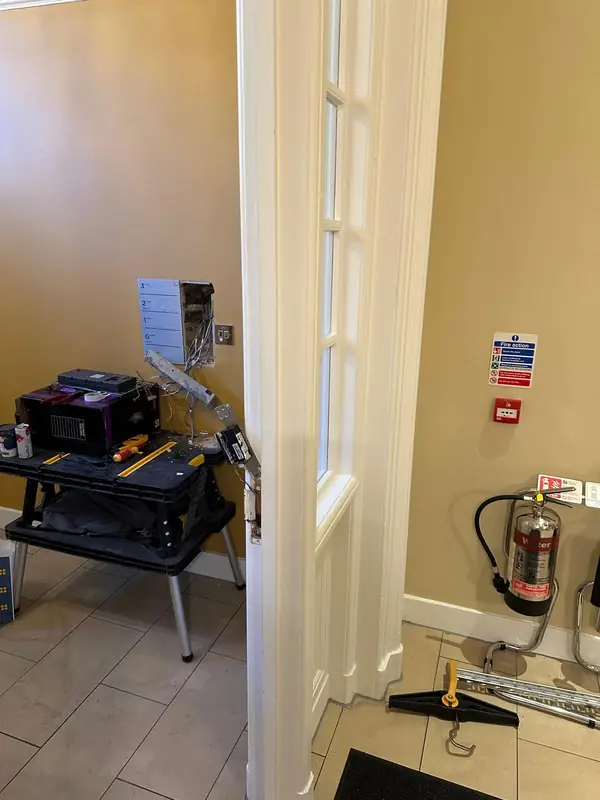 The entrance hall with the old door entry panel off the wall and the door release opened up