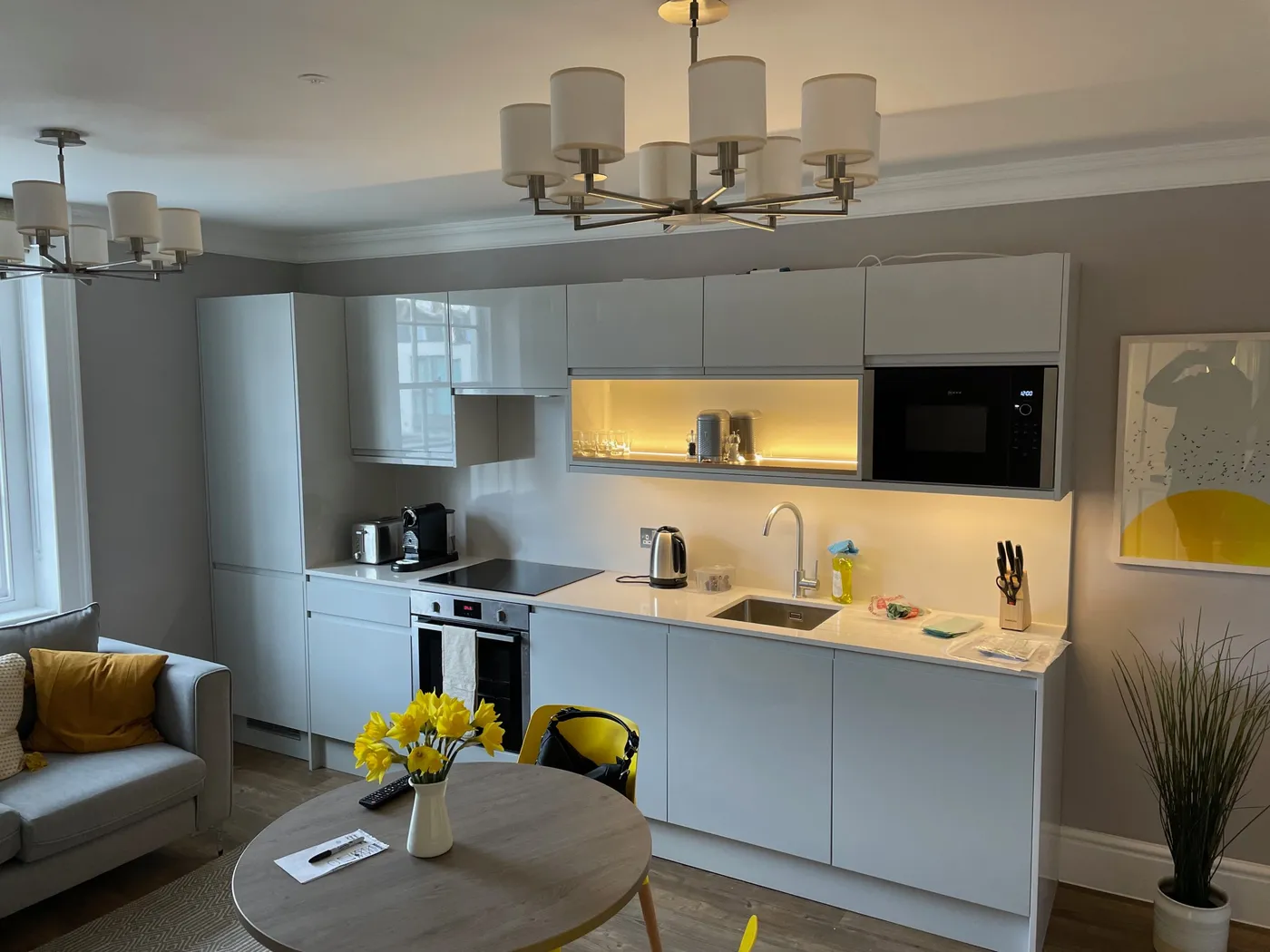 Studio kitchen and living room at 37 Doughty Street serviced apartments, Bloomsbury, with chandeliers and LED shelf lighting