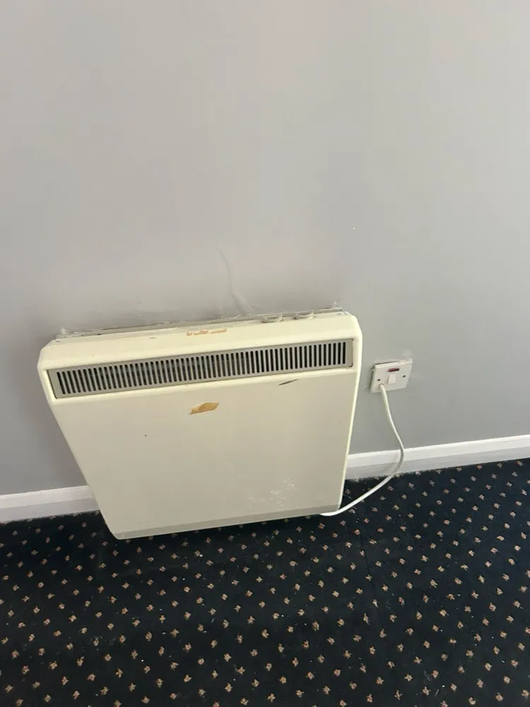 Old storage heater with worn casing in a retirement flat in Stevenage
