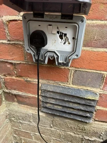 Melted outdoor double socket with a plug still in it, Harpenden