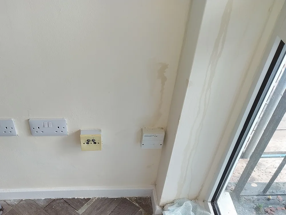 Water running down a wall beside sockets