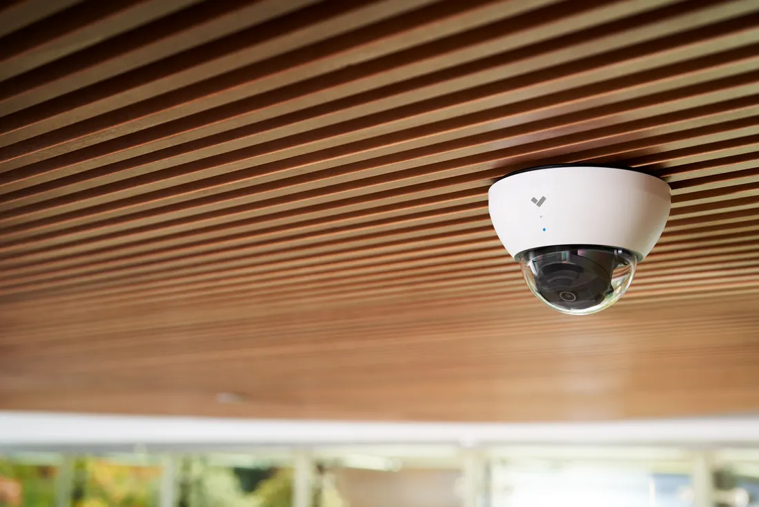 Verkada dome camera under a timber-slatted ceiling